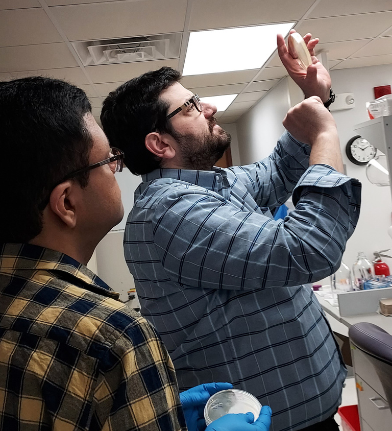 Dr. Tanas and a researcher looking at a sample